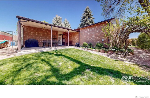 729 Jay Pl, Berthoud, CO 80513 - view of front of house featuring brick siding, a patio area, and a front yard