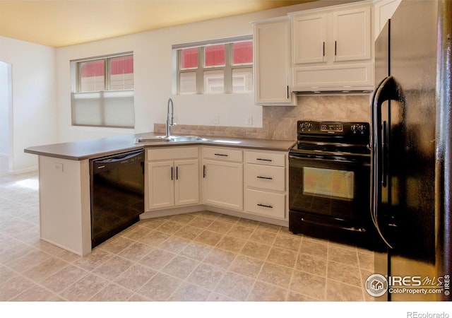 kitchen with a peninsula, white cabinetry, tasteful backsplash, a sink, and black appliances