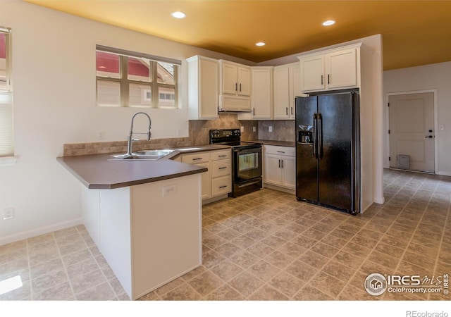 kitchen featuring decorative backsplash, a peninsula, dark countertops, a sink, and black appliances