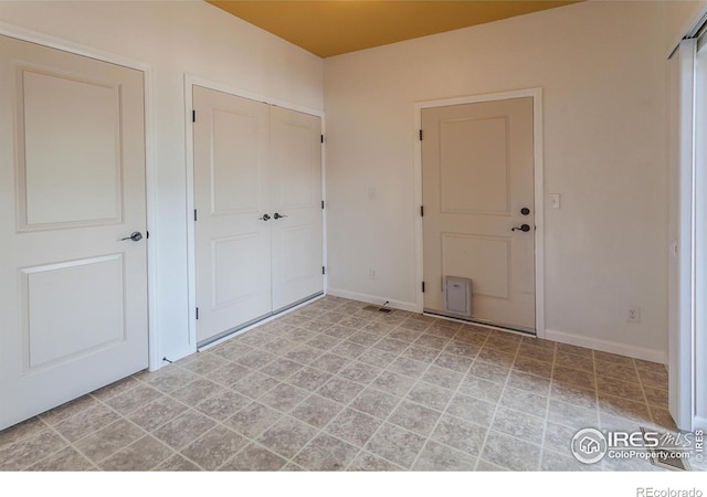 unfurnished bedroom with baseboards, a closet, and visible vents