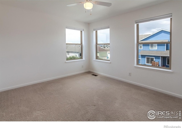 unfurnished room featuring baseboards, a ceiling fan, and carpet