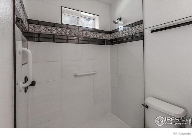 full bathroom featuring toilet and tiled shower