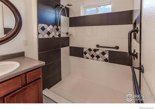full bath with vanity and a tile shower