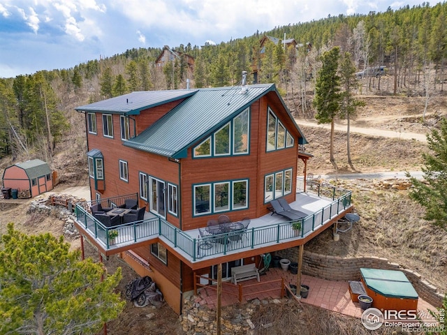 139 Ponderosa Dr, Nederland, CO 80466 - rear view of house with a view of trees, a deck, metal roof, and a patio