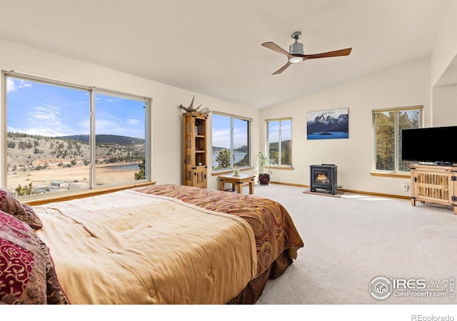 139 Ponderosa Dr, Nederland, CO 80466 - carpeted bedroom with a wood stove, lofted ceiling, baseboards, a mountain view, and multiple windows