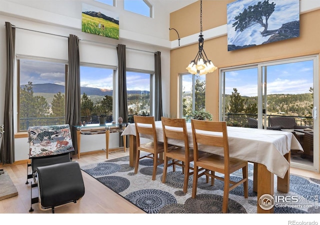 139 Ponderosa Dr, Nederland, CO 80466 - dining area with plenty of natural light, a chandelier, a towering ceiling, and wood finished floors