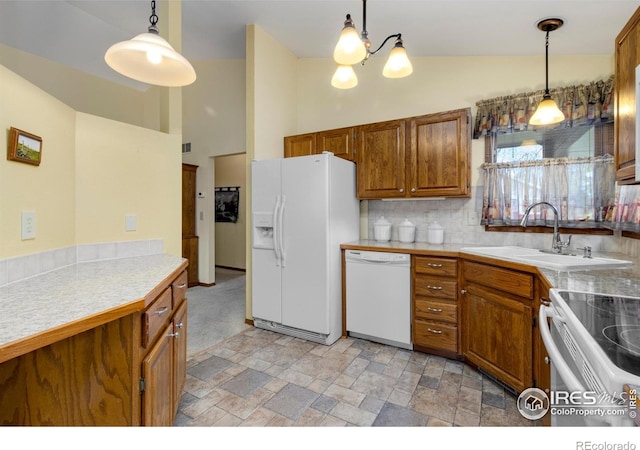 3500 Carlton Ave Unit 34, Fort Collins, CO 80525 - kitchen featuring a sink, white appliances, brown cabinets, stone finish flooring, and hanging light fixtures