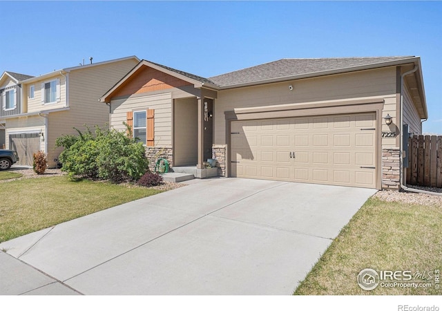 view of front of home featuring a garage, fence, a front lawn, concrete driveway, and stone siding