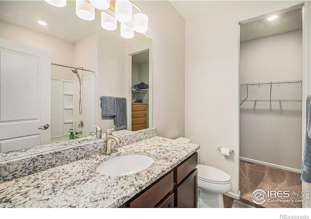 bathroom featuring vanity, a shower, toilet, a walk in closet, and recessed lighting
