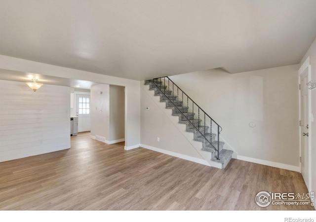 221 Chestnut St, Windsor, CO 80550 - unfurnished living room featuring wood finished floors, stairs, and baseboards