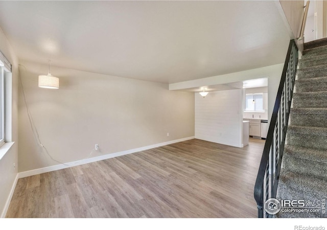 221 Chestnut St, Windsor, CO 80550 - unfurnished living room with light wood-style floors, baseboards, and stairs