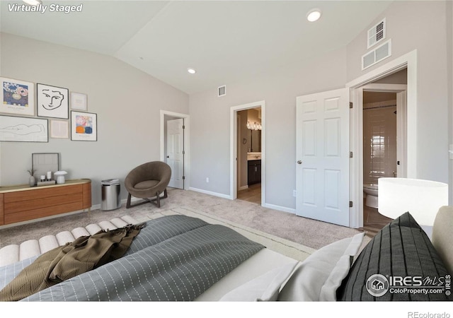 bedroom featuring carpet floors, ensuite bathroom, vaulted ceiling, and visible vents