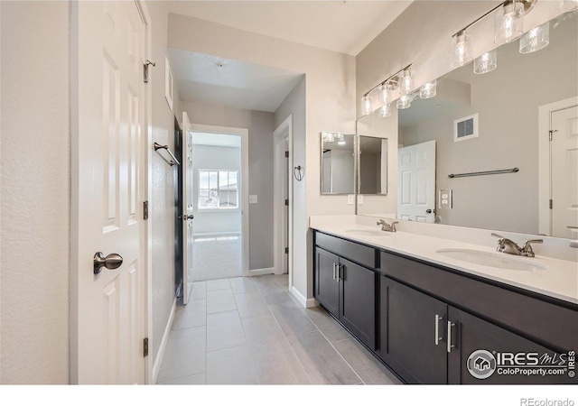 bathroom with visible vents, a sink, baseboards, and tile patterned flooring