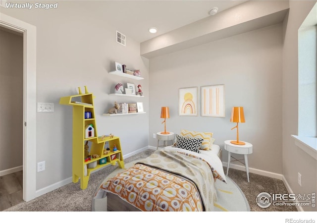 carpeted bedroom featuring baseboards and visible vents
