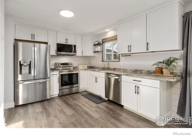 2139 Donna Ct, Loveland, CO 80537 - kitchen with a sink, wood finished floors, white cabinets, and stainless steel appliances