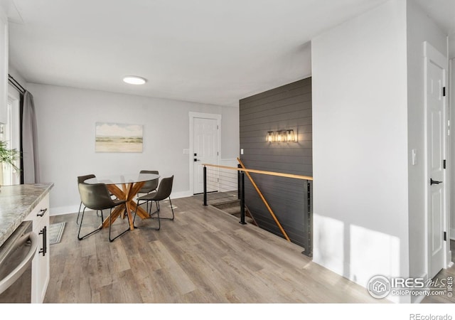 2139 Donna Ct, Loveland, CO 80537 - dining room with baseboards, wood walls, an accent wall, and light wood-type flooring