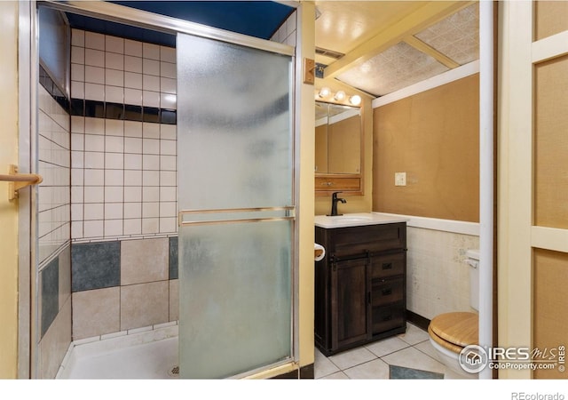 2139 Donna Ct, Loveland, CO 80537 - bathroom featuring tile walls, tile patterned flooring, a stall shower, and toilet