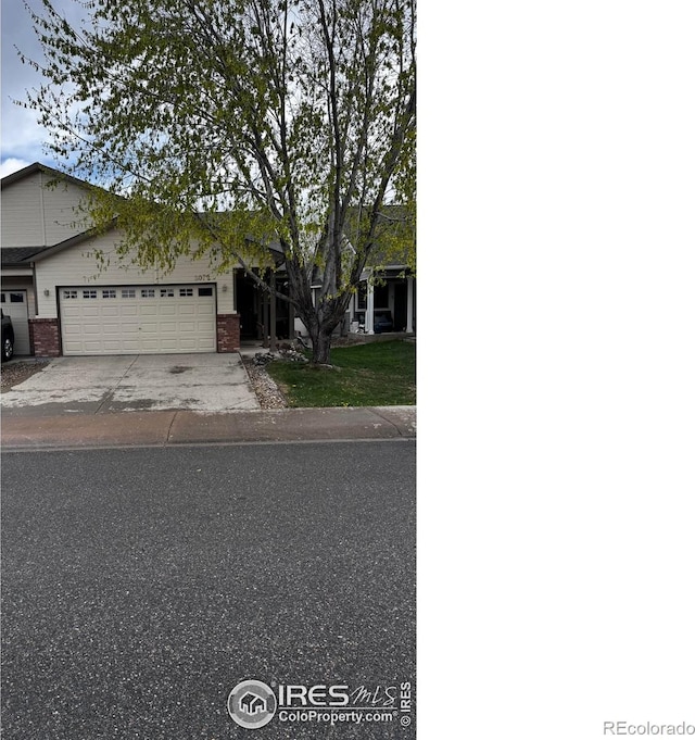 2072 Lily Dr, Loveland, CO 80537 - ranch-style home with concrete driveway, a garage, and brick siding