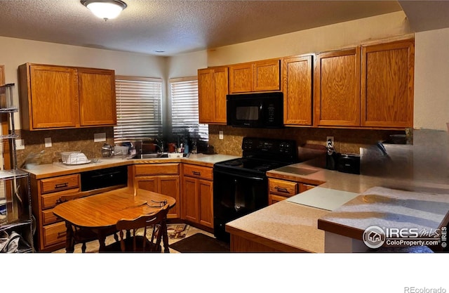2072 Lily Dr, Loveland, CO 80537 - kitchen with a sink, a textured ceiling, decorative backsplash, and black appliances