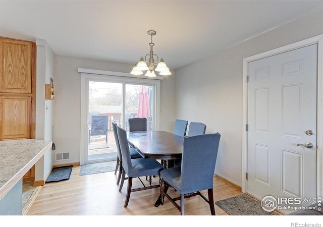 10538 Quivas St, Northglenn, CO 80234 - dining area featuring a chandelier, light wood finished floors, and baseboards
