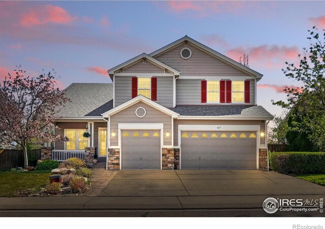 665 Glenarbor Cir, Longmont, CO 80504 - view of front of house featuring a garage, stone siding, a shingled roof, concrete driveway, and a porch