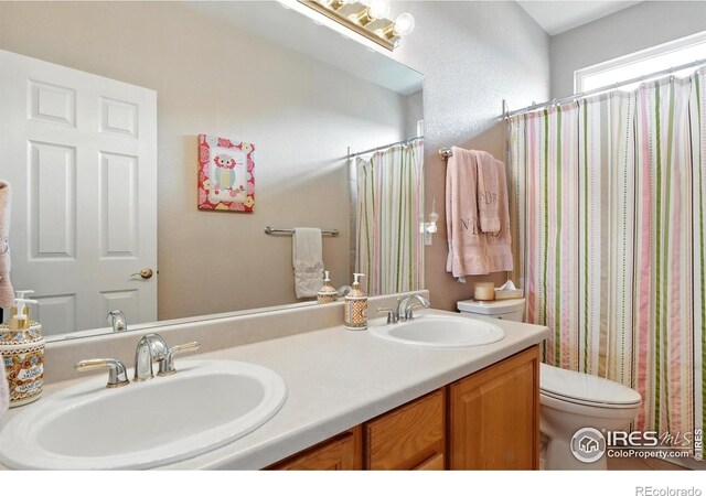 665 Glenarbor Cir, Longmont, CO 80504 - full bathroom featuring double vanity, toilet, a shower with shower curtain, and a sink