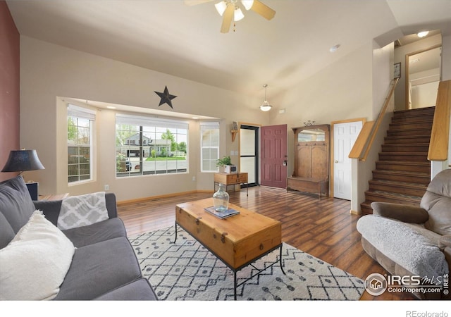 living room with stairs, a ceiling fan, wood finished floors, and lofted ceiling