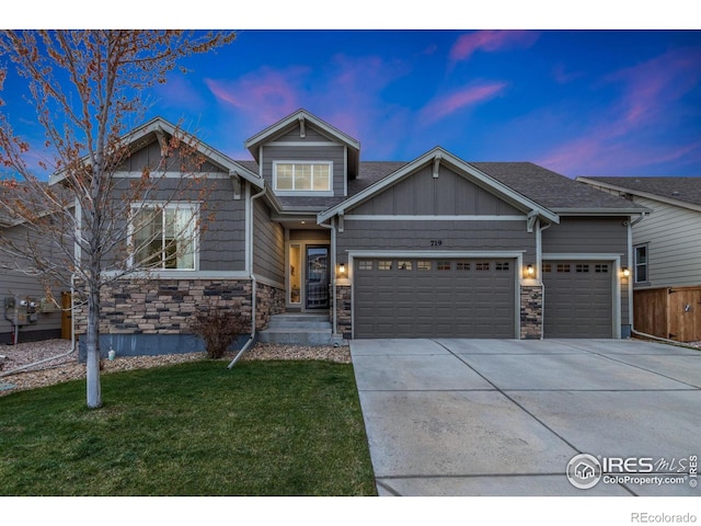 719 Wagon Bend Rd, Berthoud, CO 80513 - view of front of home with fence, an attached garage, stone siding, a front yard, and driveway