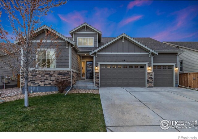719 Wagon Bend Rd, Berthoud, CO 80513 - view of front of home with fence, an attached garage, stone siding, a front yard, and driveway
