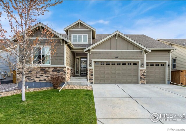 719 Wagon Bend Rd, Berthoud, CO 80513 - craftsman house featuring an attached garage, a shingled roof, stone siding, a front yard, and concrete driveway