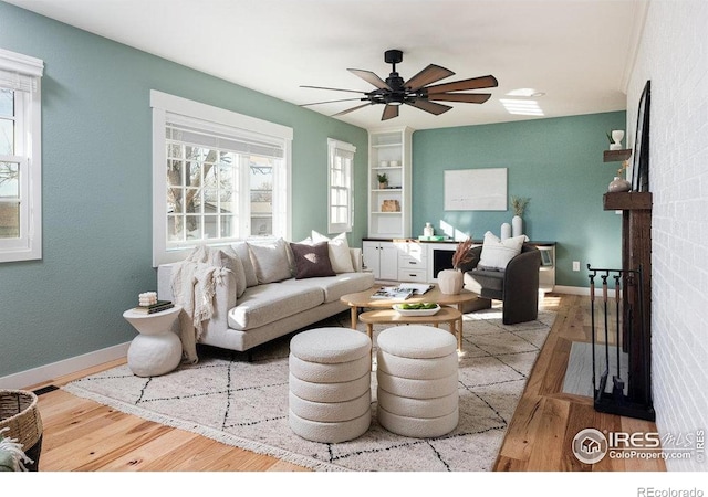 living area featuring a ceiling fan, wood finished floors, and a wealth of natural light