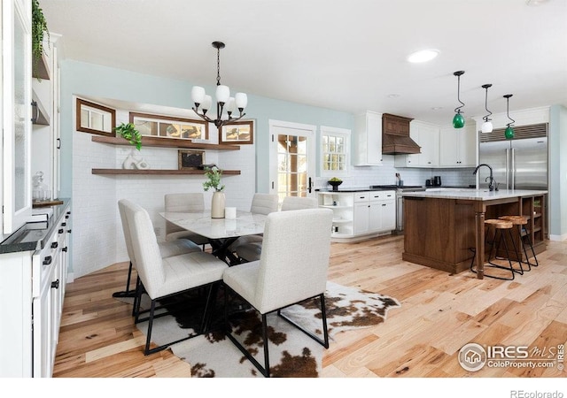 dining area featuring light wood-type flooring and a chandelier