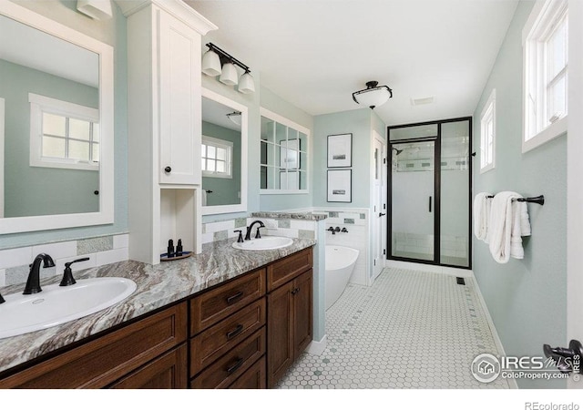 full bath with a sink, a soaking tub, a shower stall, and double vanity