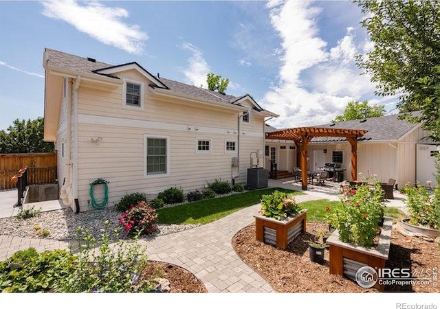 rear view of house featuring a pergola, fence, central AC unit, and a patio