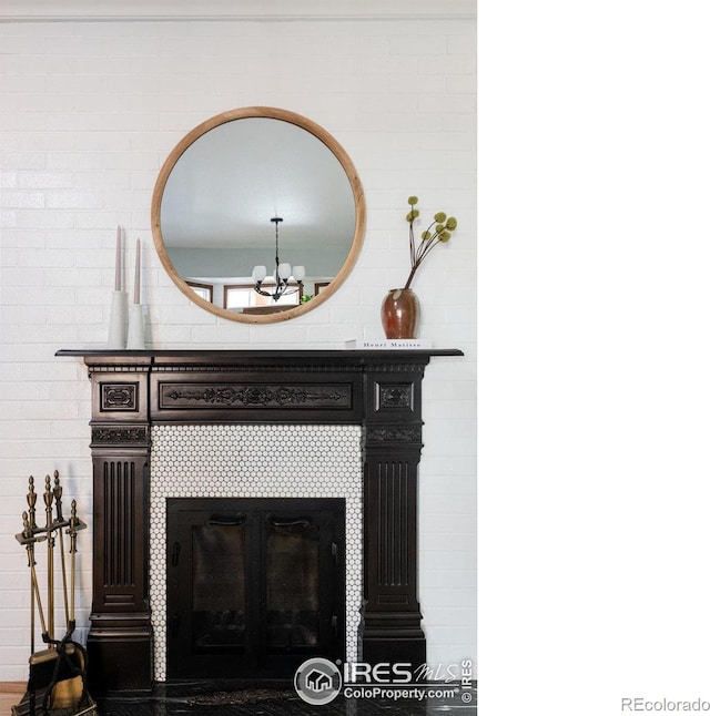 room details featuring a tile fireplace and an inviting chandelier