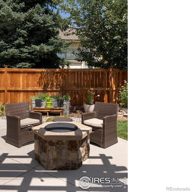 view of patio with fence and a fire pit