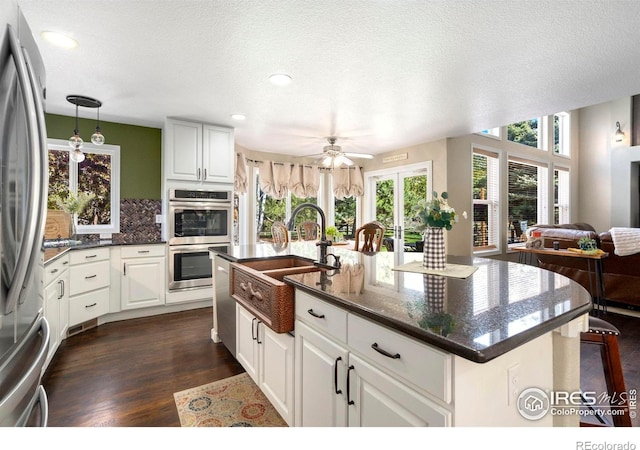 5442 Tiller Ct, Windsor, CO 80528 - kitchen featuring ceiling fan, a sink, dark wood-style floors, open floor plan, and stainless steel appliances