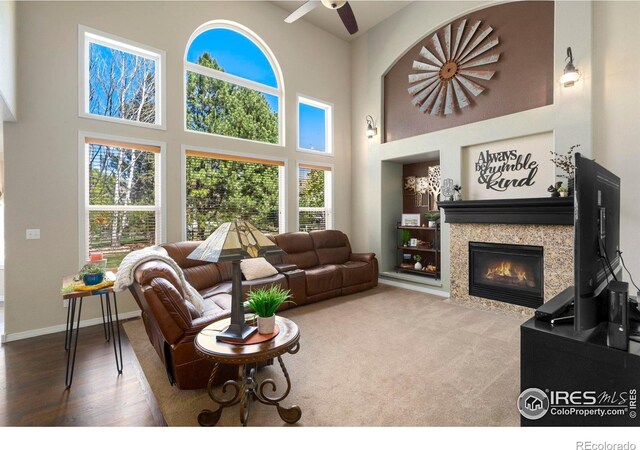 5442 Tiller Ct, Windsor, CO 80528 - living area with a towering ceiling, wood finished floors, a fireplace, baseboards, and ceiling fan