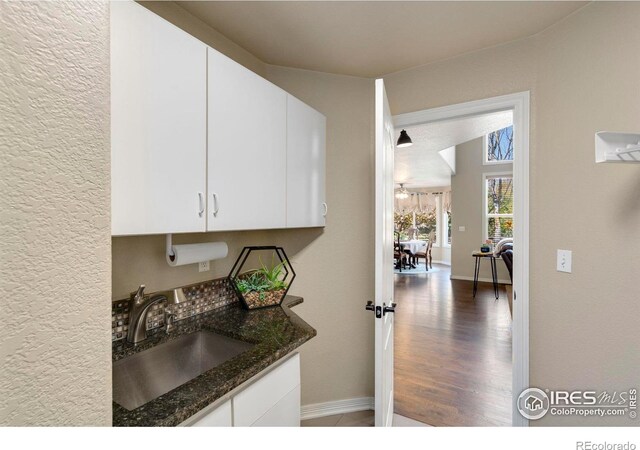 5442 Tiller Ct, Windsor, CO 80528 - laundry room featuring baseboards, a sink, and wood finished floors