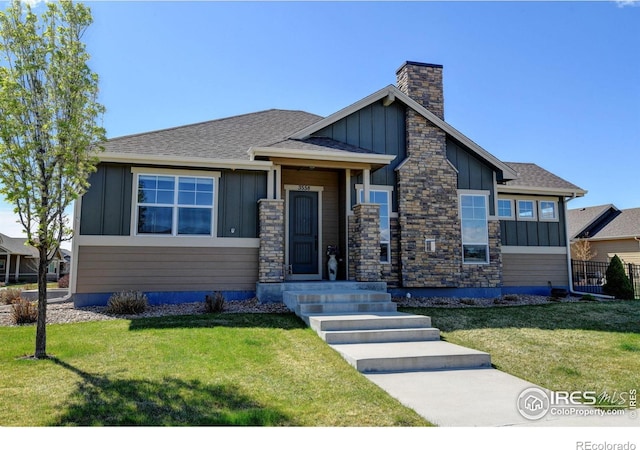 3558 Prickly Pear Dr, Loveland, CO 80537 - view of front of home with board and batten siding, roof with shingles, a chimney, and a front yard