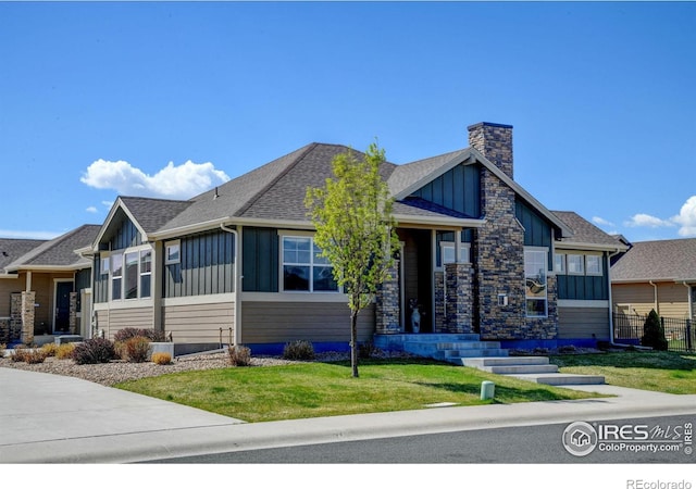 3558 Prickly Pear Dr, Loveland, CO 80537 - ranch-style house featuring board and batten siding, a chimney, roof with shingles, fence, and a front lawn