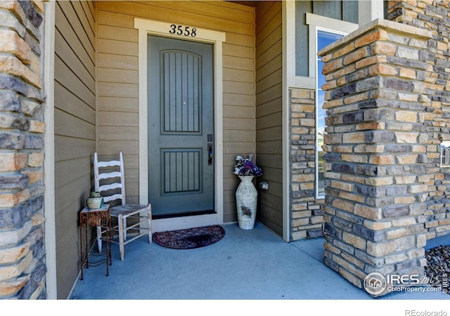 3558 Prickly Pear Dr, Loveland, CO 80537 - view of exterior entry featuring a porch and stone siding