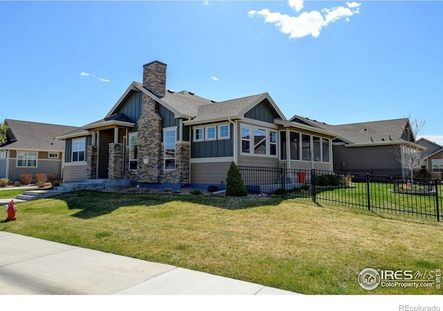 3558 Prickly Pear Dr, Loveland, CO 80537 - view of front facade with a sunroom, a front lawn, board and batten siding, and fence