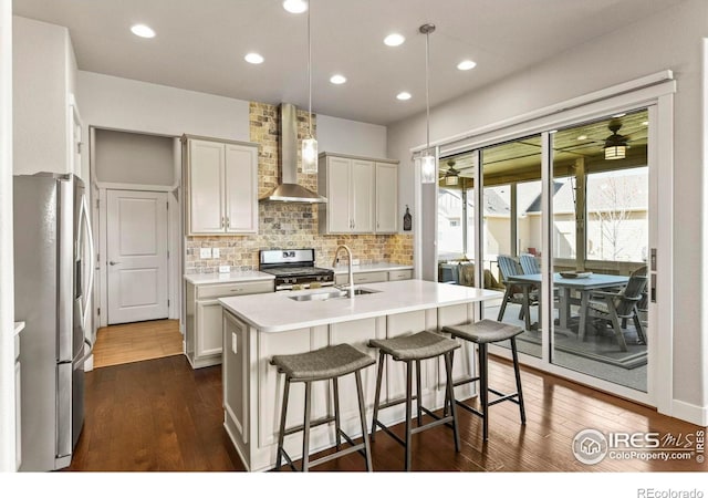 3558 Prickly Pear Dr, Loveland, CO 80537 - kitchen featuring appliances with stainless steel finishes, a sink, an island with sink, wall chimney exhaust hood, and backsplash