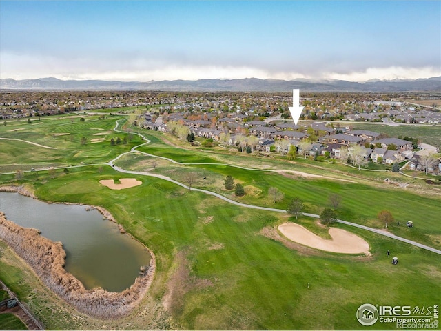 view of property location featuring nearby suburban area, a water and mountain view, and a golf club