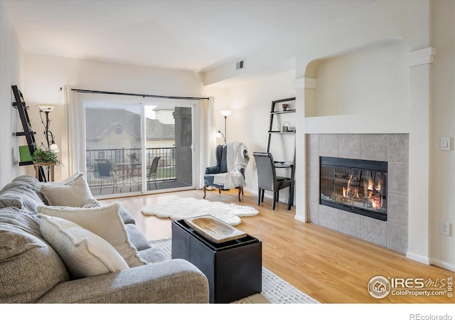 living room featuring wood finished floors, a fireplace, and baseboards