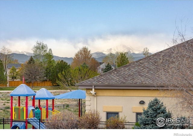 exterior space featuring a mountain view, stucco siding, and a shingled roof