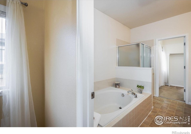 bathroom featuring a garden tub and a shower