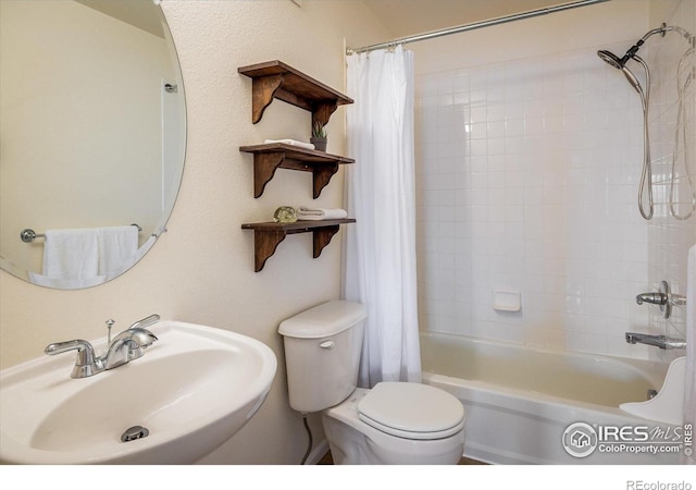 bathroom featuring a sink, toilet, and shower / bathtub combination with curtain