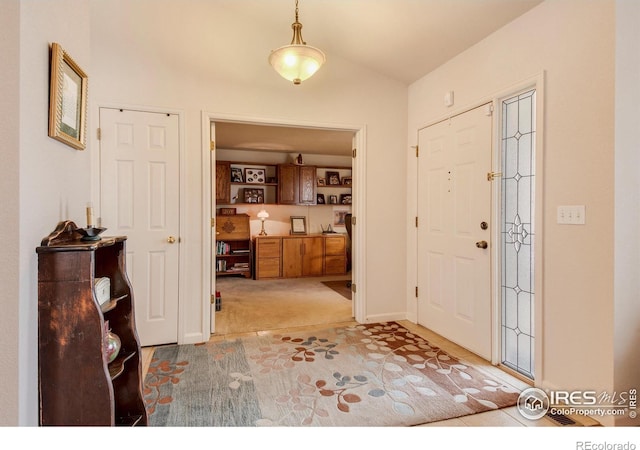 carpeted foyer entrance with vaulted ceiling